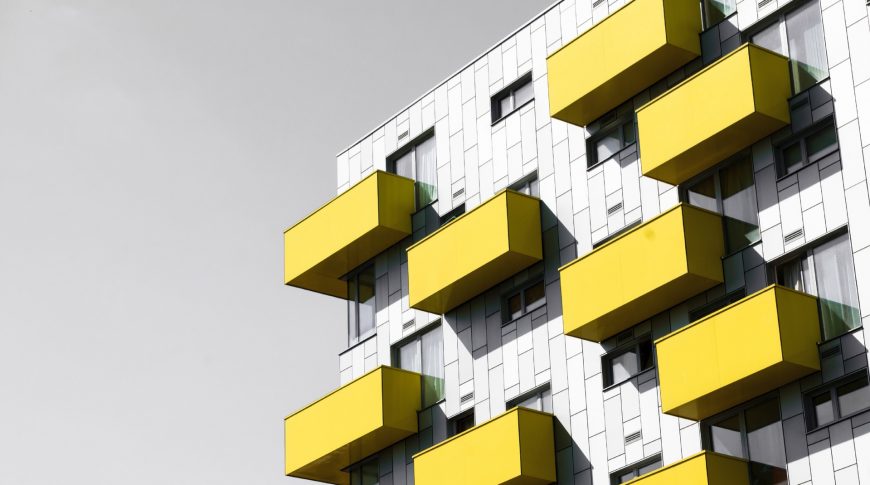 Modern apartments with balconies set against a blue sky